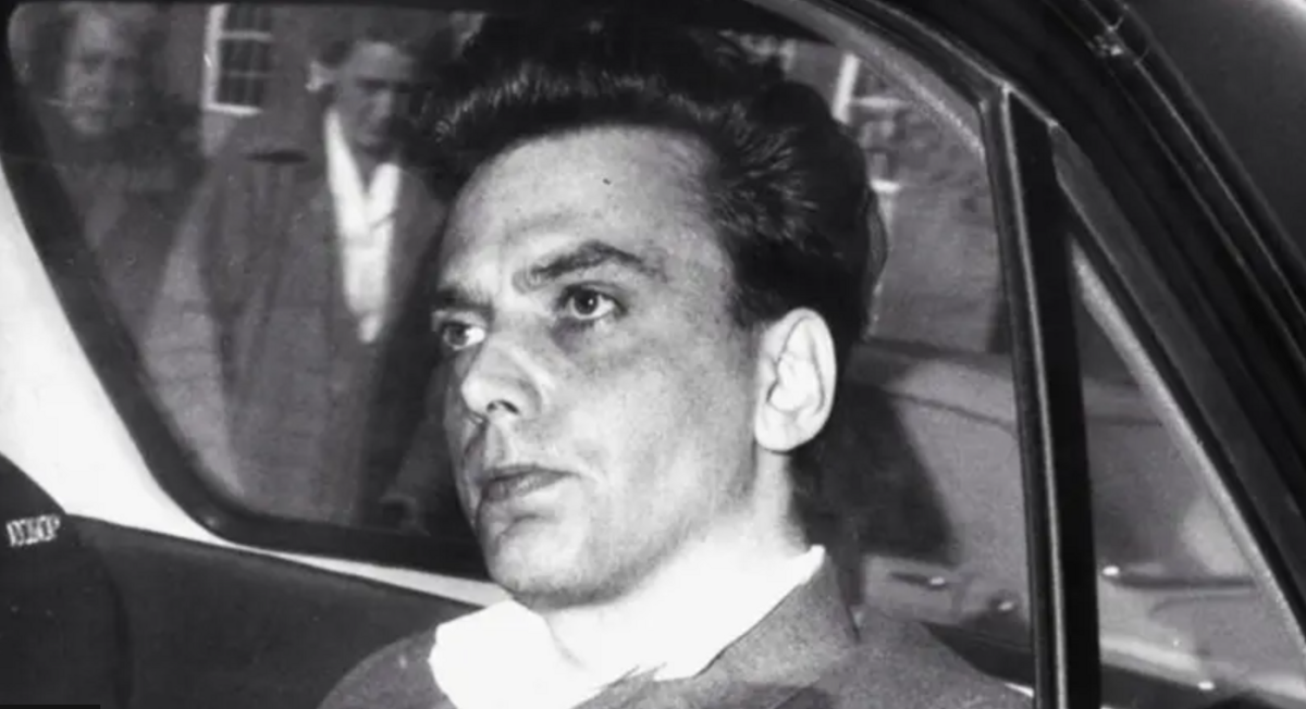 An unsmiling Ian Brady pictured in a police car, looking straight ahead
