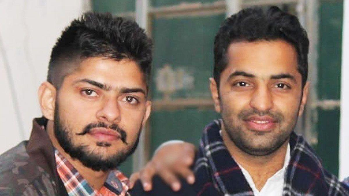 Lawrence Bishnoi and Vicky Middukhera both look at the camera - Bishnoi has a carefully groomed moustache and Middukhera is smiling and wearing a checked scarf.