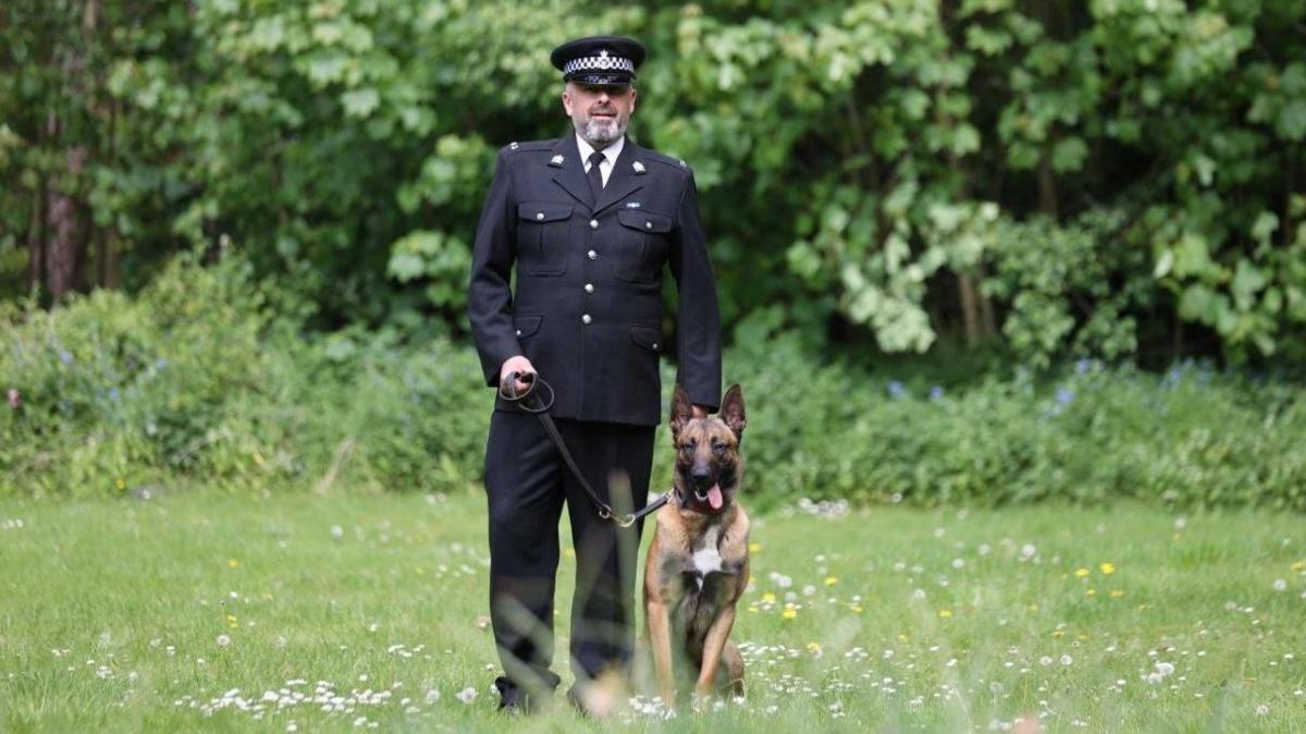 Police Dog Russo sat with PC Lee Huffer