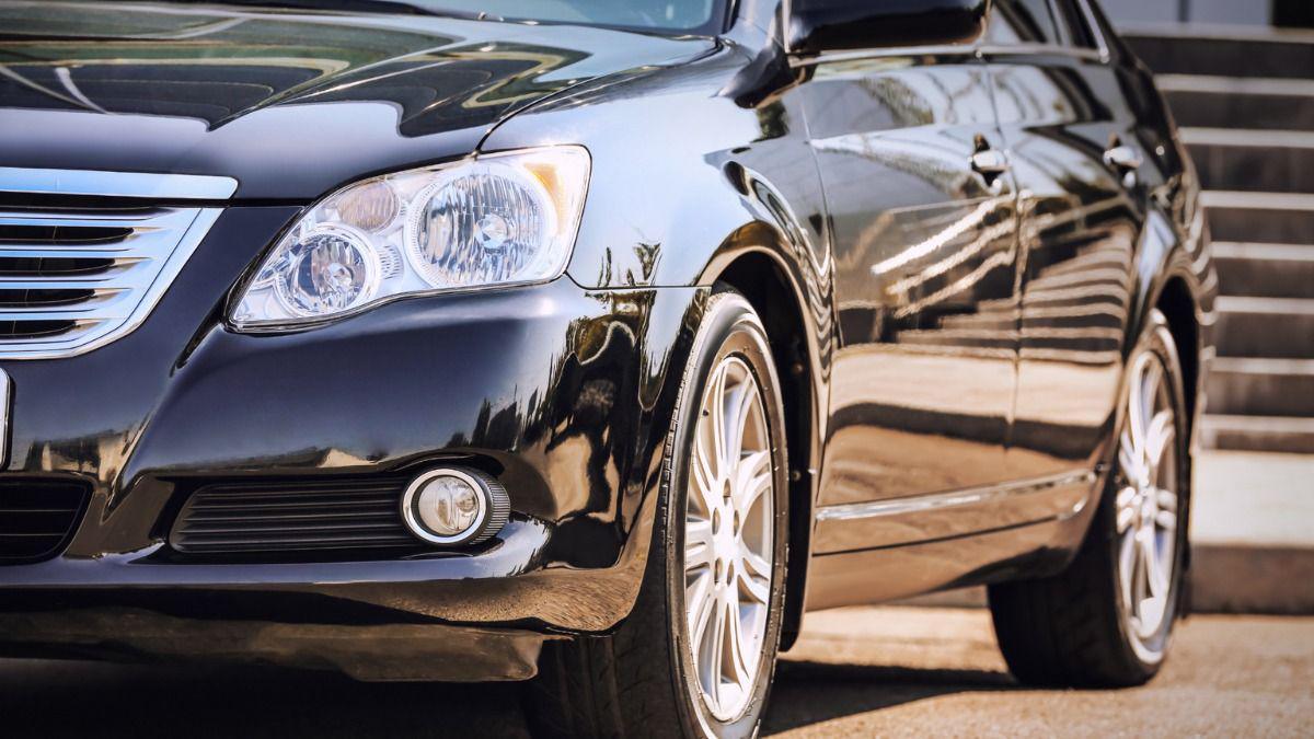 A close-up photo of a black car, with a flight of steps behind it.