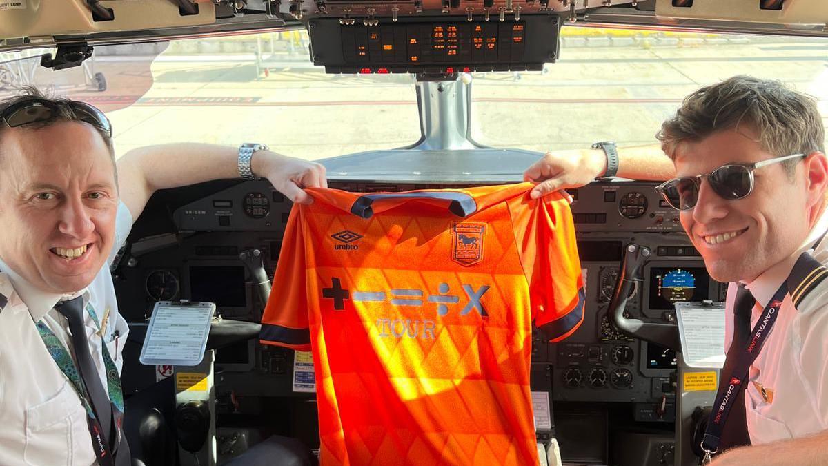 Two of Scott Billison's pilots with his Ipswich Town shirt on his flight home