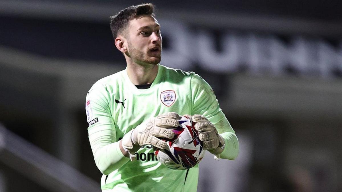 Jackson Smith holding the ball during a game for Barnsley