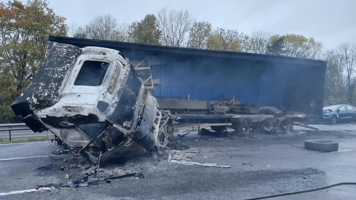 A burned out lorry with a blue trailer
