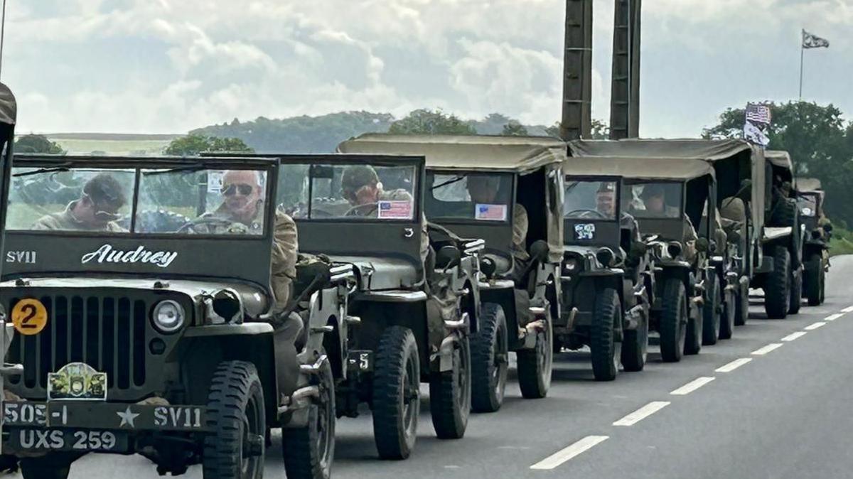 A line of military jeeps on a road