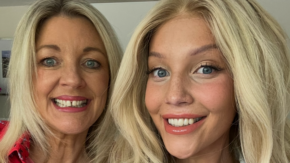 Izzy Fletcher and her mother smile at the camera. They both have long, blonde hair and are wearing make-up.