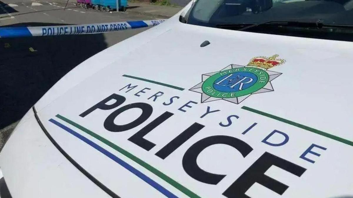 Merseyside Police vehicle inside a police cordon with blue and white police tape on a street