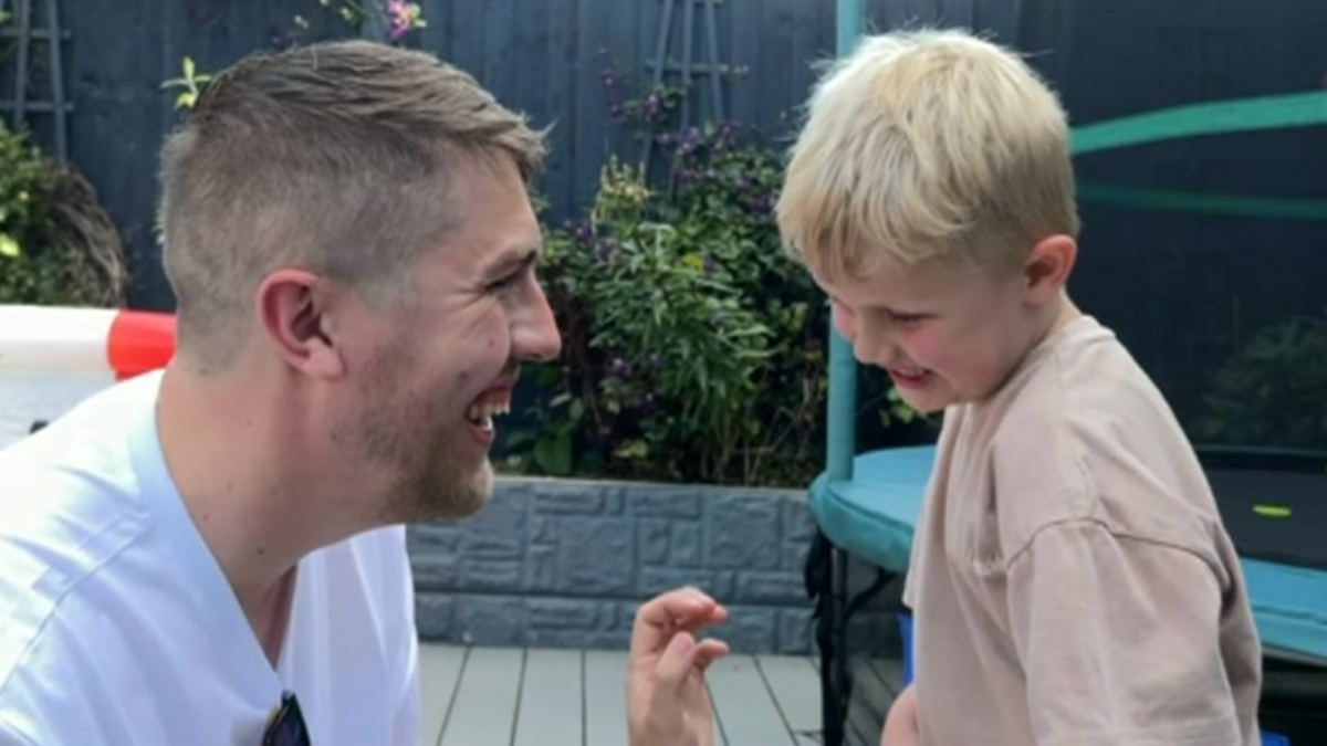 Zach in and his father in front of a trampoline in their garden