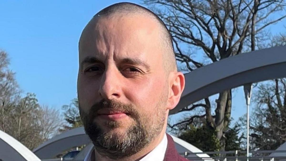 A man, Jérémie Fernandes, looks seriously into the camera. He has short hair and a brown beard, flecked with grey. 