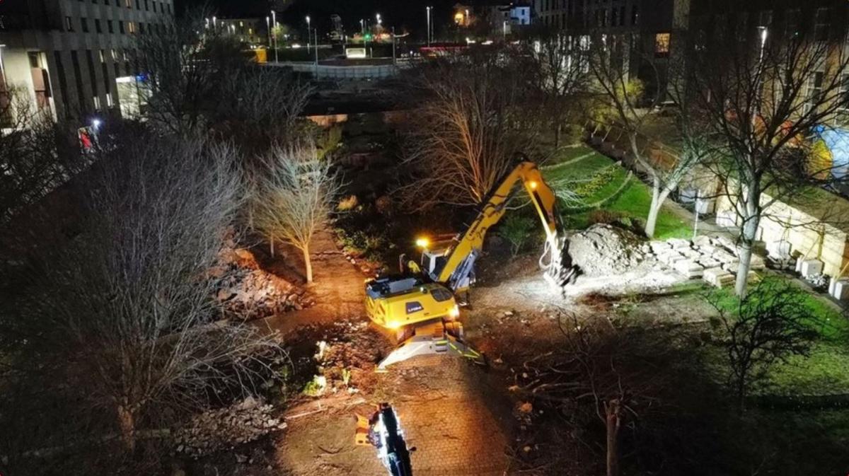 Plant machinery carrying out work to fell trees in Armada Way at night