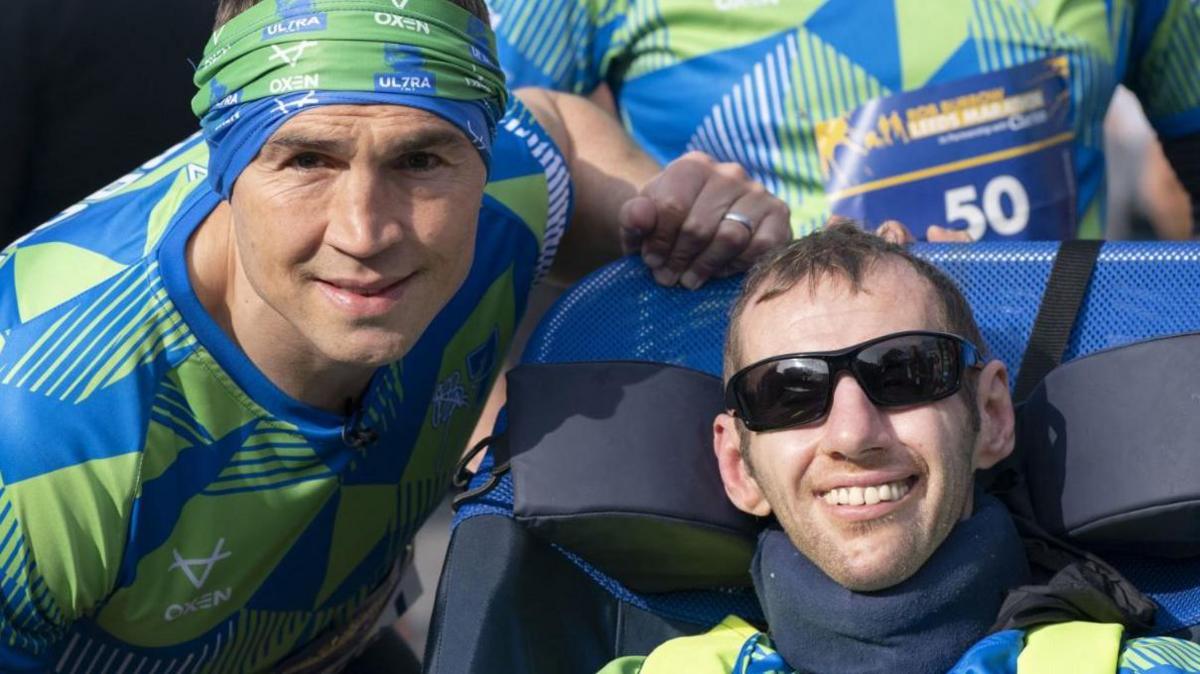 Kevin Sinfield (left), and Rob Burrow, smiling together at the start line of a race, wearing racing clothing.
