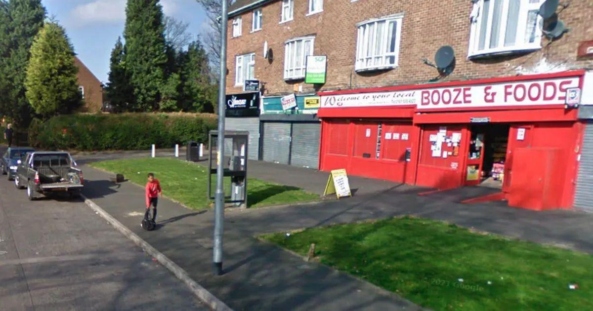 A row of shops including convenience shop on Button Lane in Wythenshawe Manchester in 2009. An 11-year-old Marcus Rashford with a bag in his hand, waits on the pavement for a lift to the  Manchester United academy.