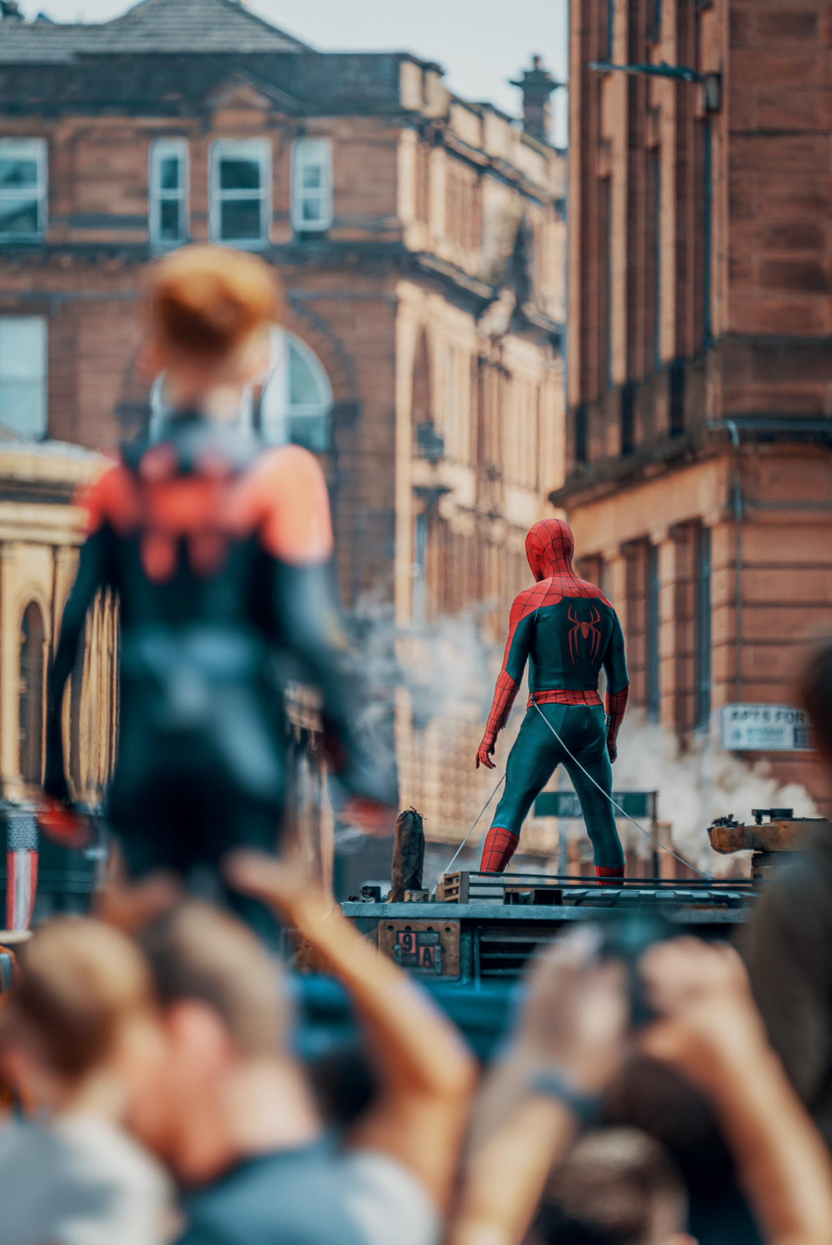 A young fan in a Spider-Man costume is held up to watch filming in Glasgow.