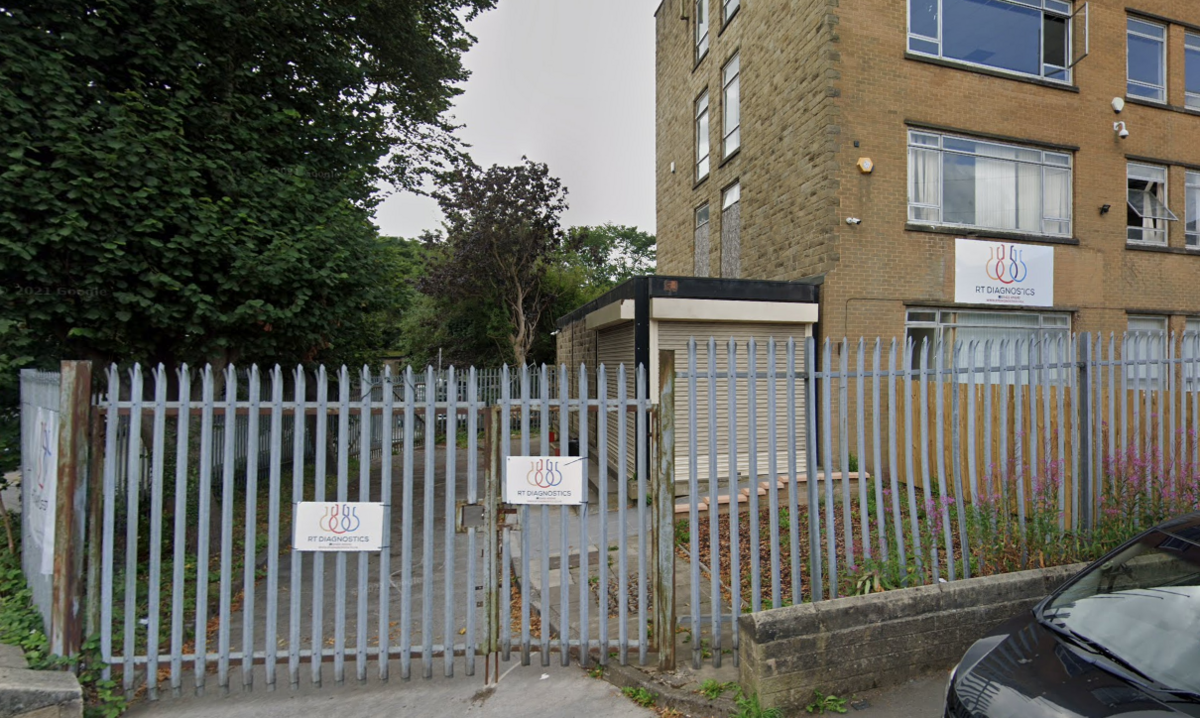 A large office-type building with a sharp-pointed metal fence around the front.