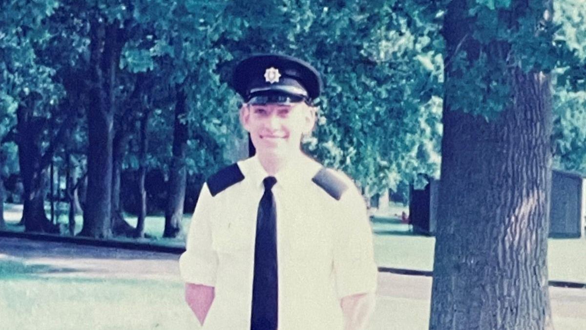 An old picture of Steve Wright at 18, wearing a shirt tie and firefighter's hat.