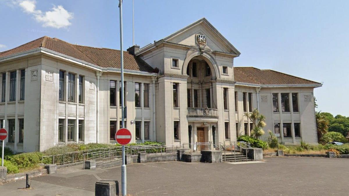 Poole Civic Centre - a wide symmetrical Art Deco municipal building built of white stone with a pitched roof. The central section has a grand entrance beneath a large recessed balcony