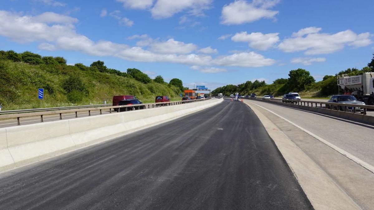 The M1 motorway, showing it with cars driving next to a concrete barrier 