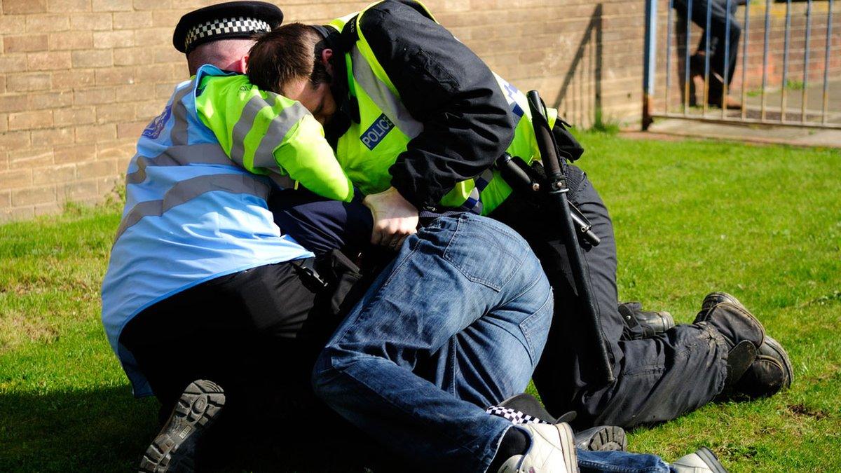 Police restrain a man