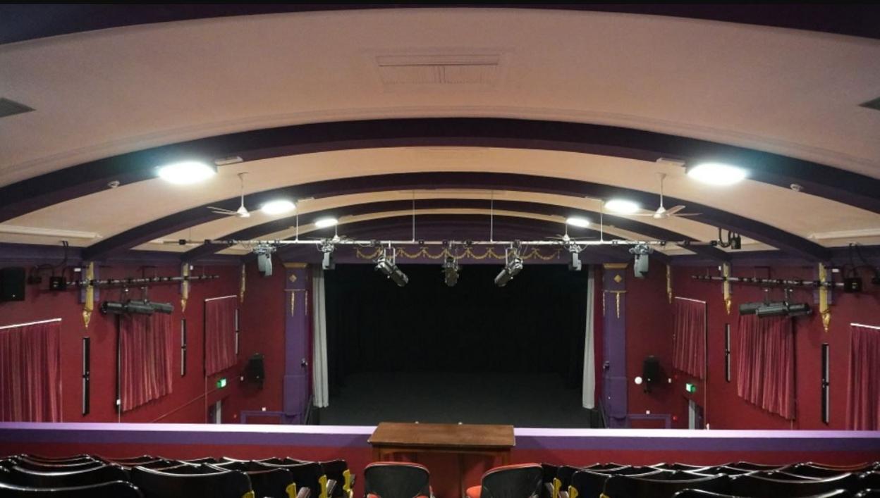 Theatre auditorium with red curtains on the stage