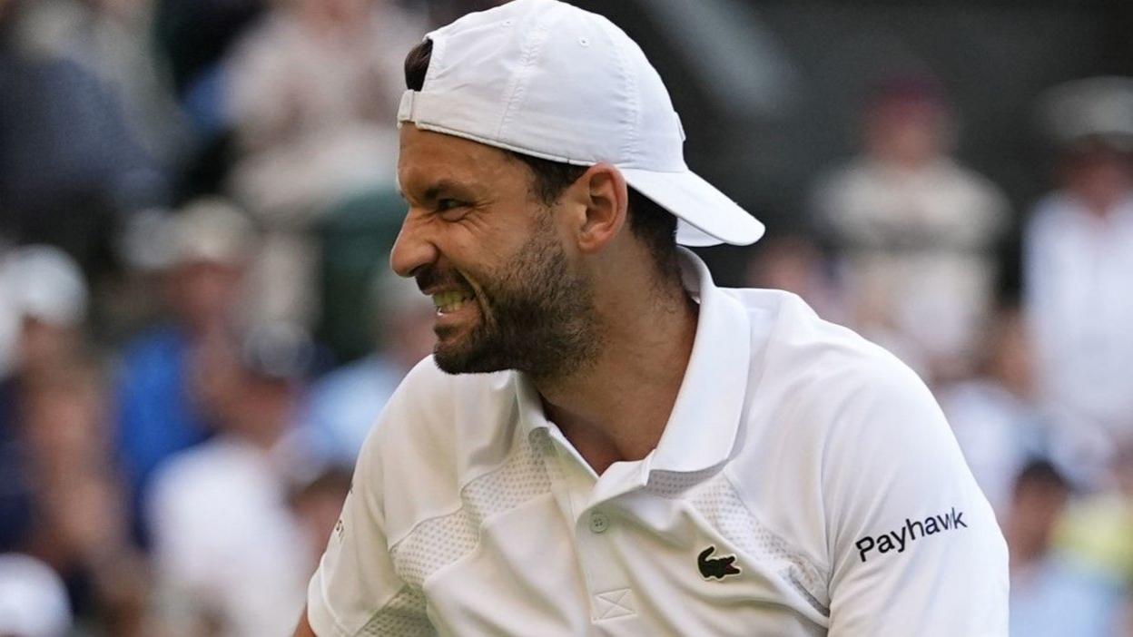 Grigor Dimitrov grimaces after injuring himself in last-16 match against Jannik Sinner at Wimbledon