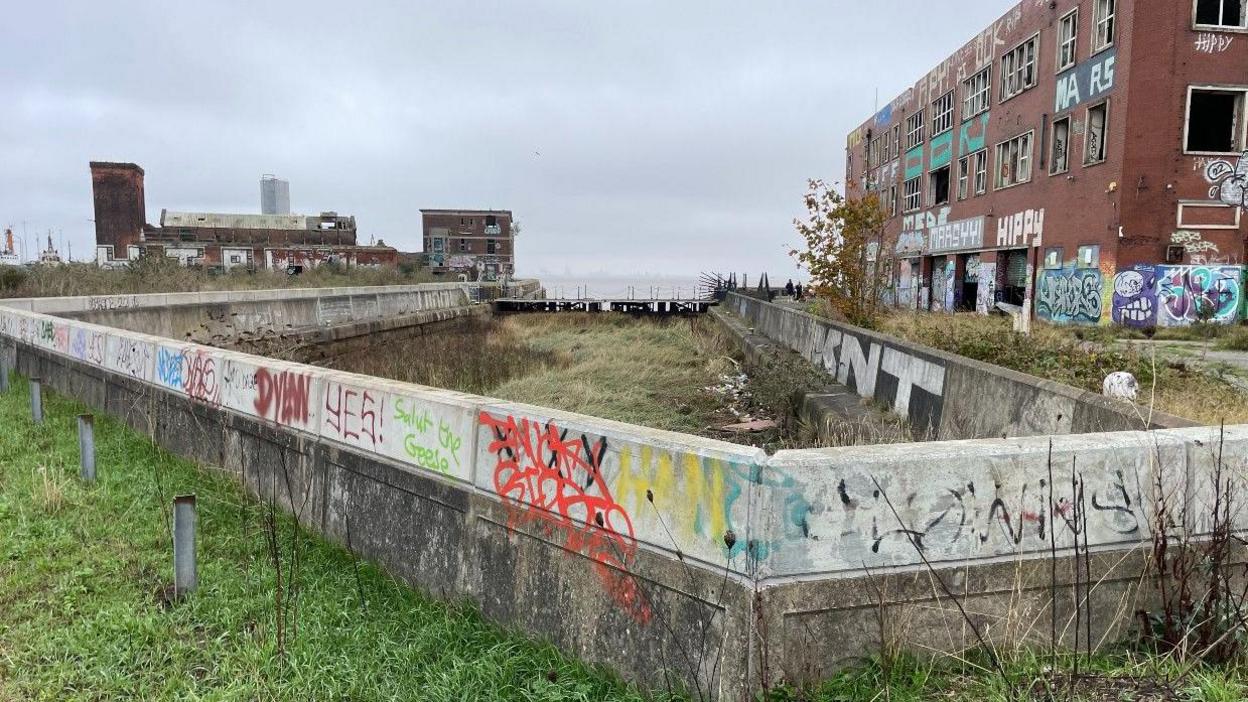 Derelict buildings at the former dock with broken windows and covered in graffiti 