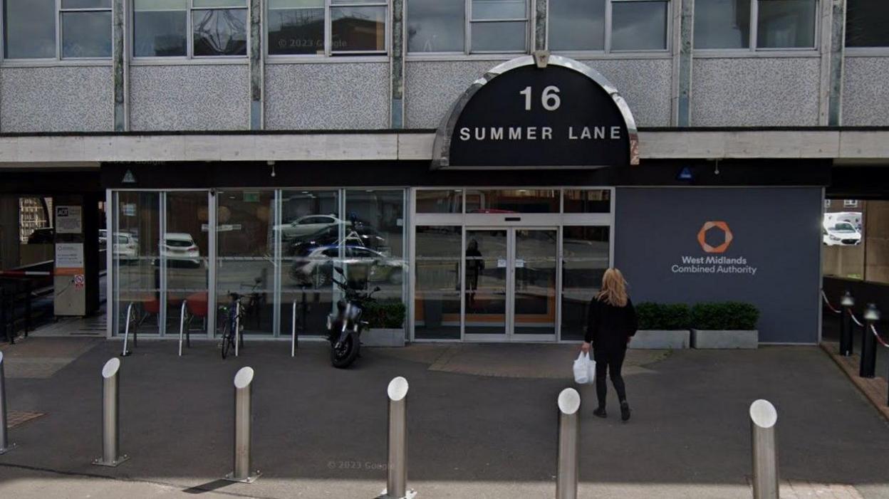 A woman can be seen walking towards the entrance to a building which has 16 Summer Lane on it, along with a sign saying West Midlands Combined Authority.