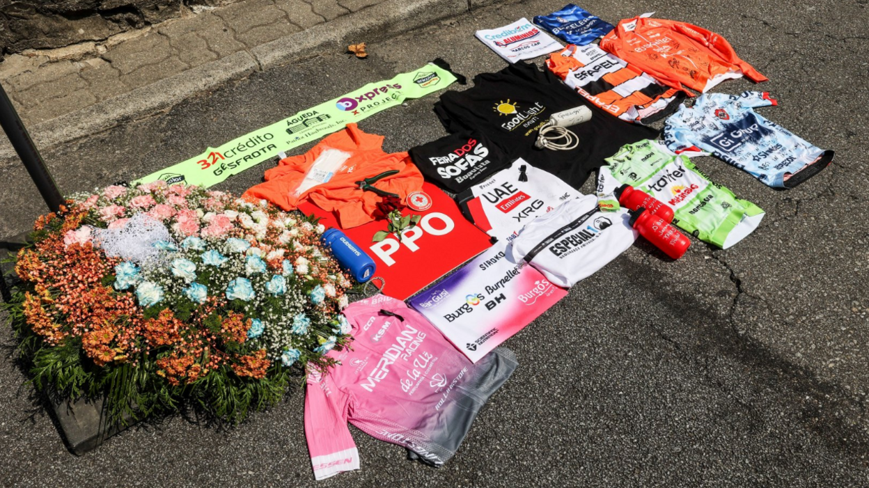 Cycling jerseys and bottles on the floor next to flowers
