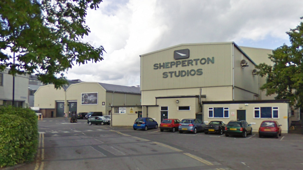 Warehouse-style building with a big sign saying 'Shepperton Studios' 