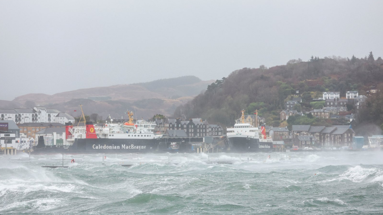 Two CalMac ferries are berthed in stormy waters at Oban harbour