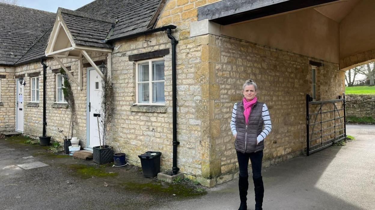 Susannah Bagnell standing next to her house