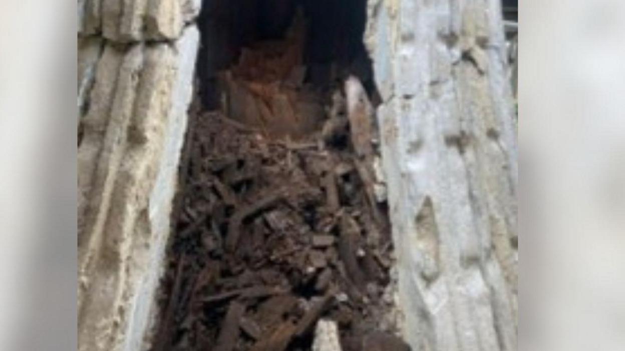 Rotten brown wood inside a grey stone render turret or dome