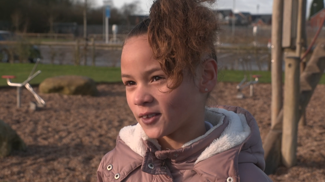 Girl wearing a pink jacket with her hair tied up