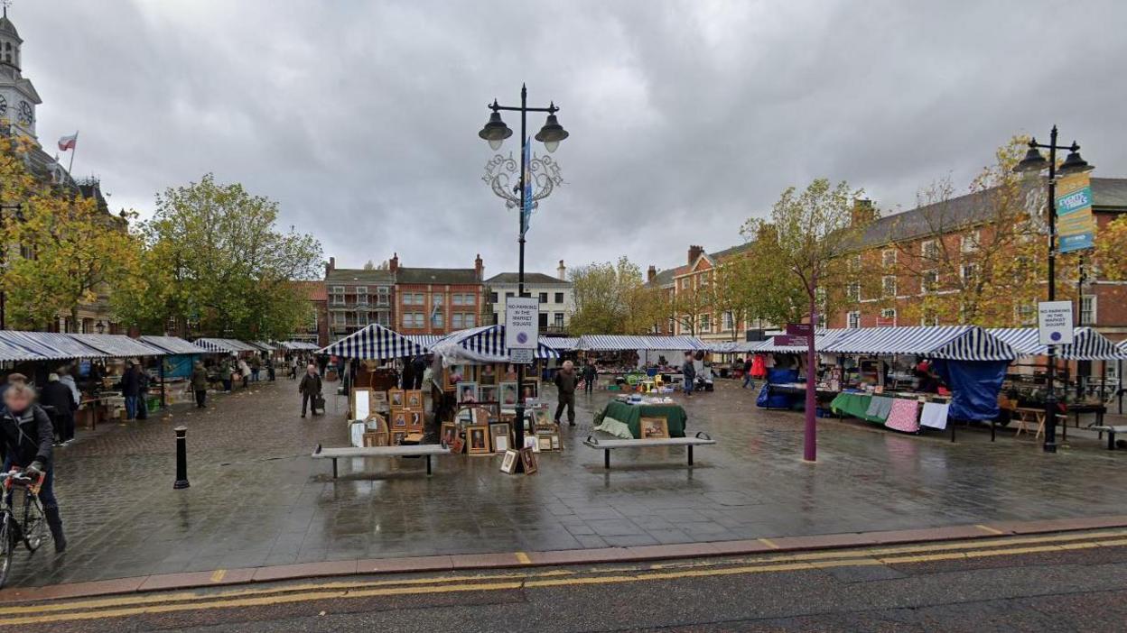 A streetview image of Retford marketplace, a wide square with more than 20 stalls surrounded by historic town houses