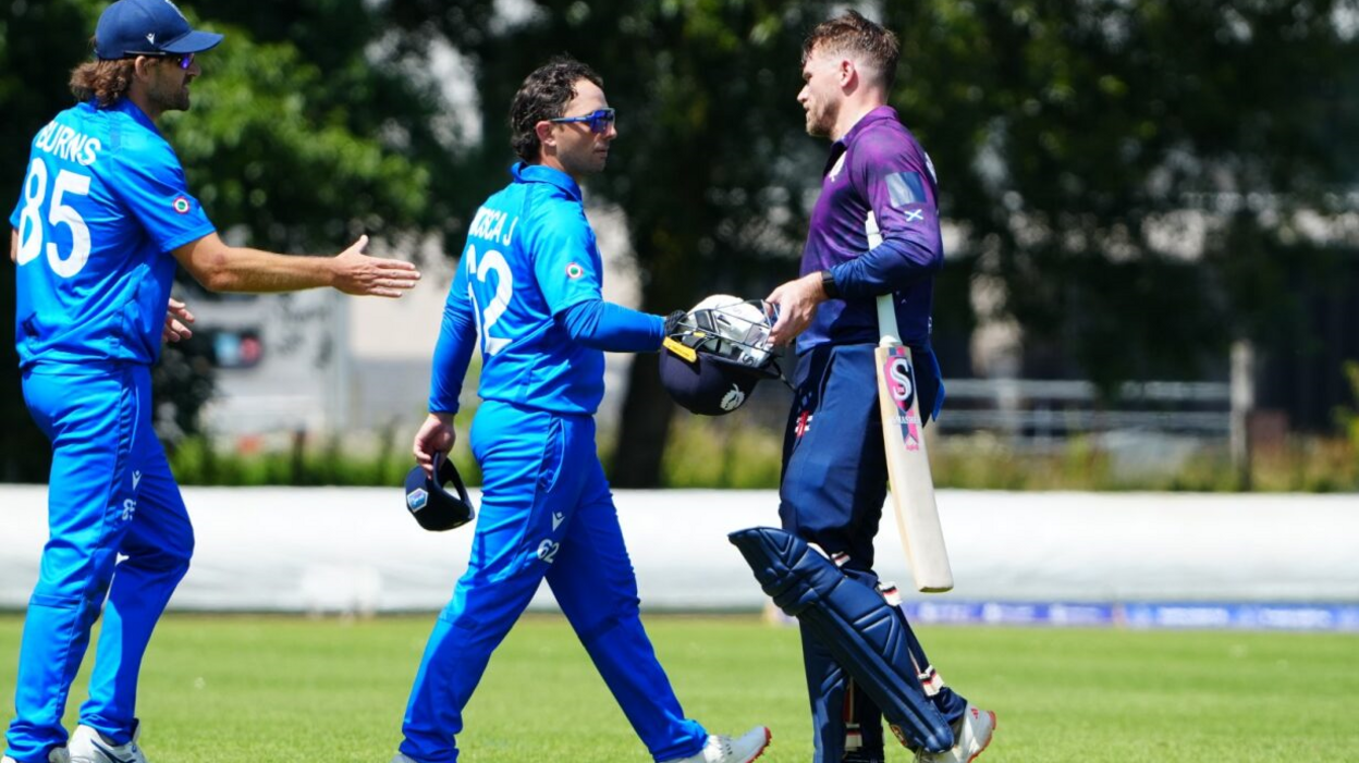 Richie Berrington shakes hands with Scotland's players as he walks off