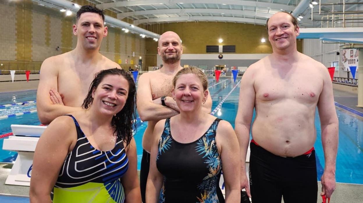 Helen Jewell, second from right, with The Channel Pirates who she is taking on the swim with. They are inside by a swimming pool.