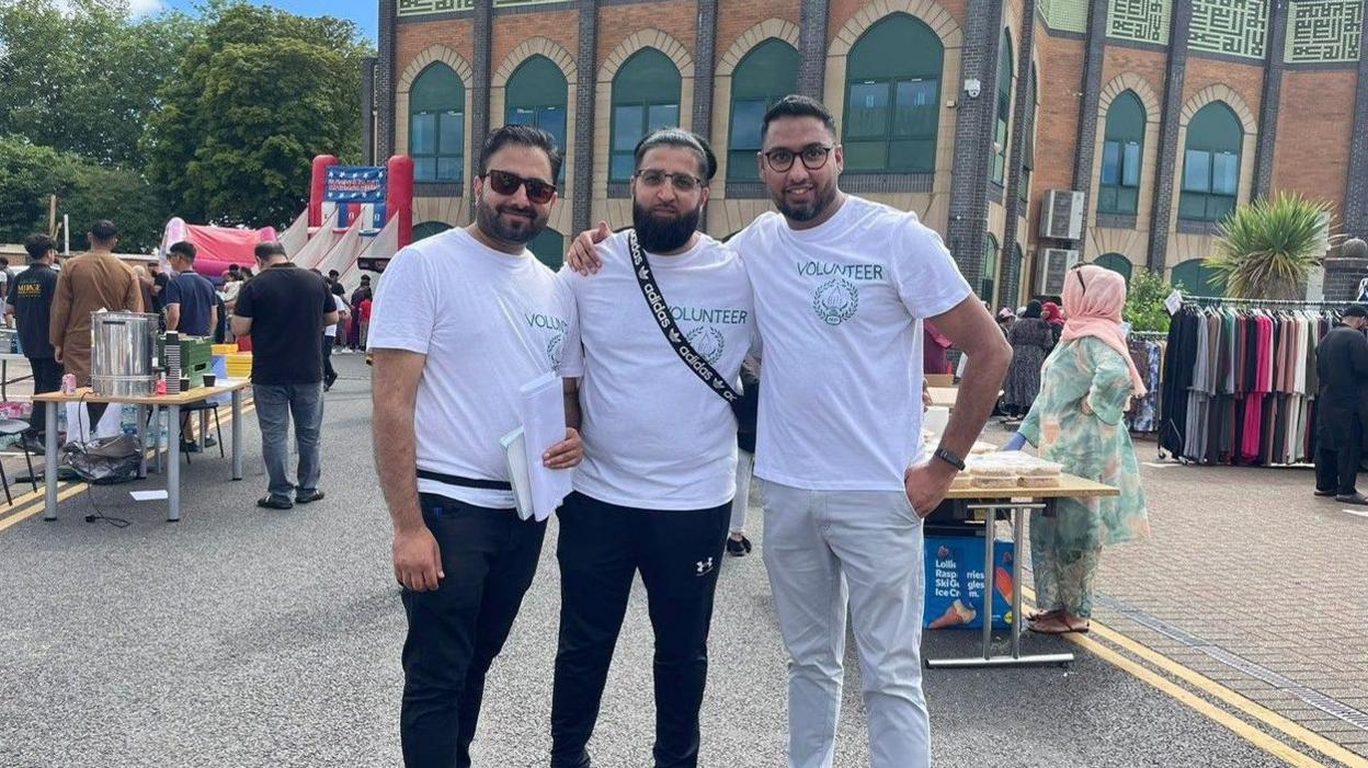 Shafeel Hussain with volunteers Abrar Ahmed and Shaz Khansmiling for camera 