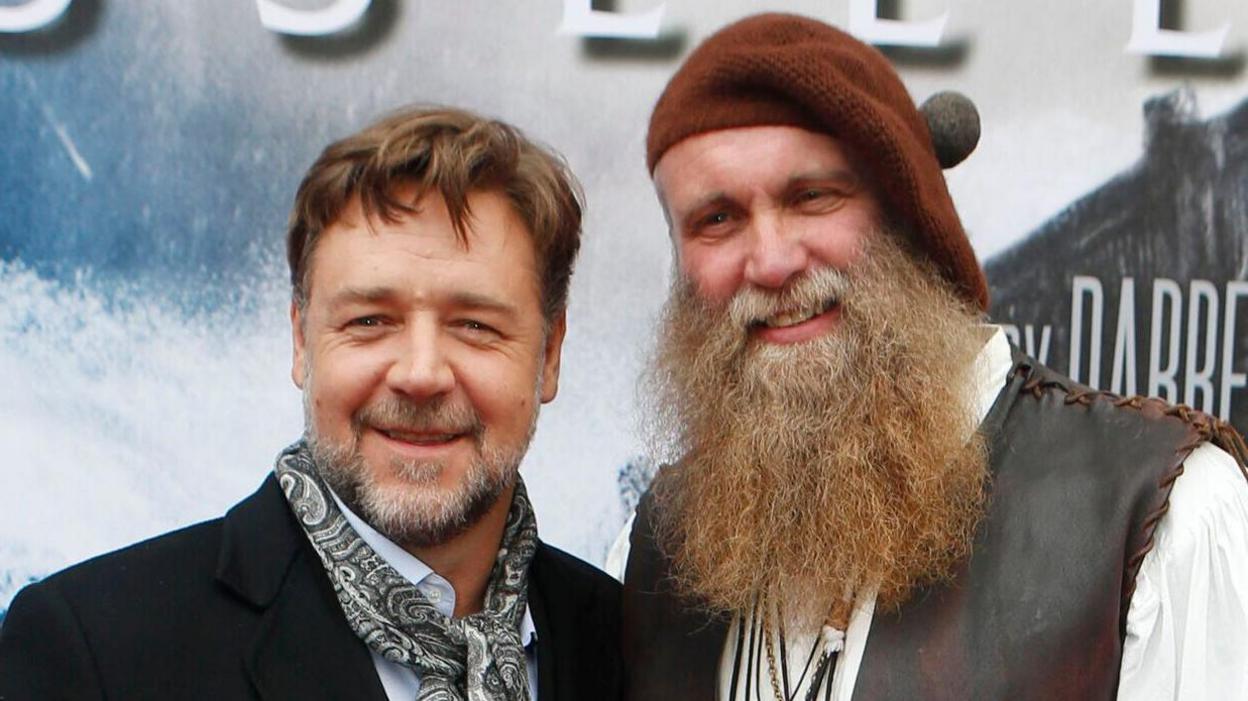 Russell Crowe (left, wearing a dark suit and a patterned grey neck tie) and Charlie Allan (right, with a brown beret and a long brown beard and a brown leather waistcoat) attending the premiere of Noah at the Film House in Edinburgh