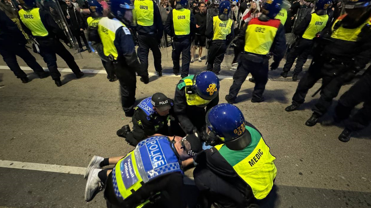 Police officers detain some far-right protesters after they tried to cross to the side of the opposing group in Plymouth