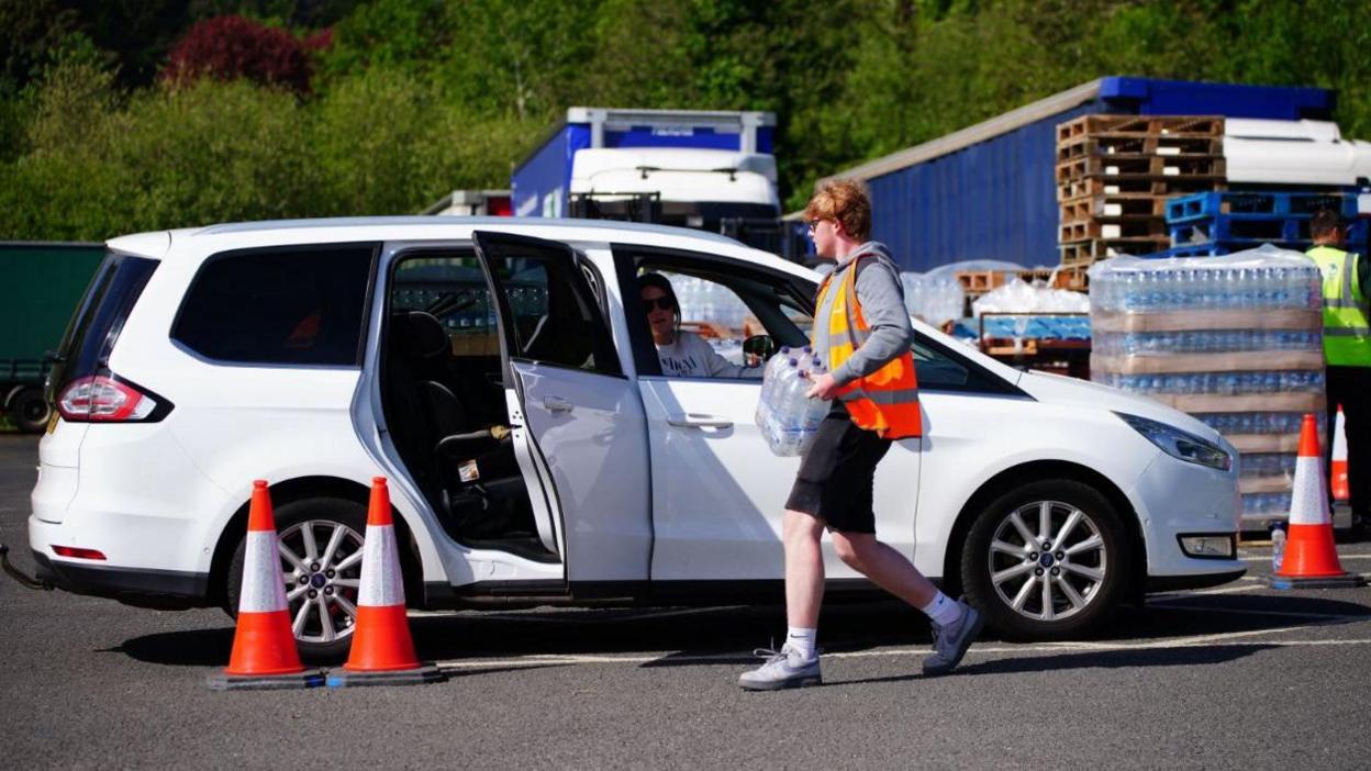 Water bottles being delivered to a car