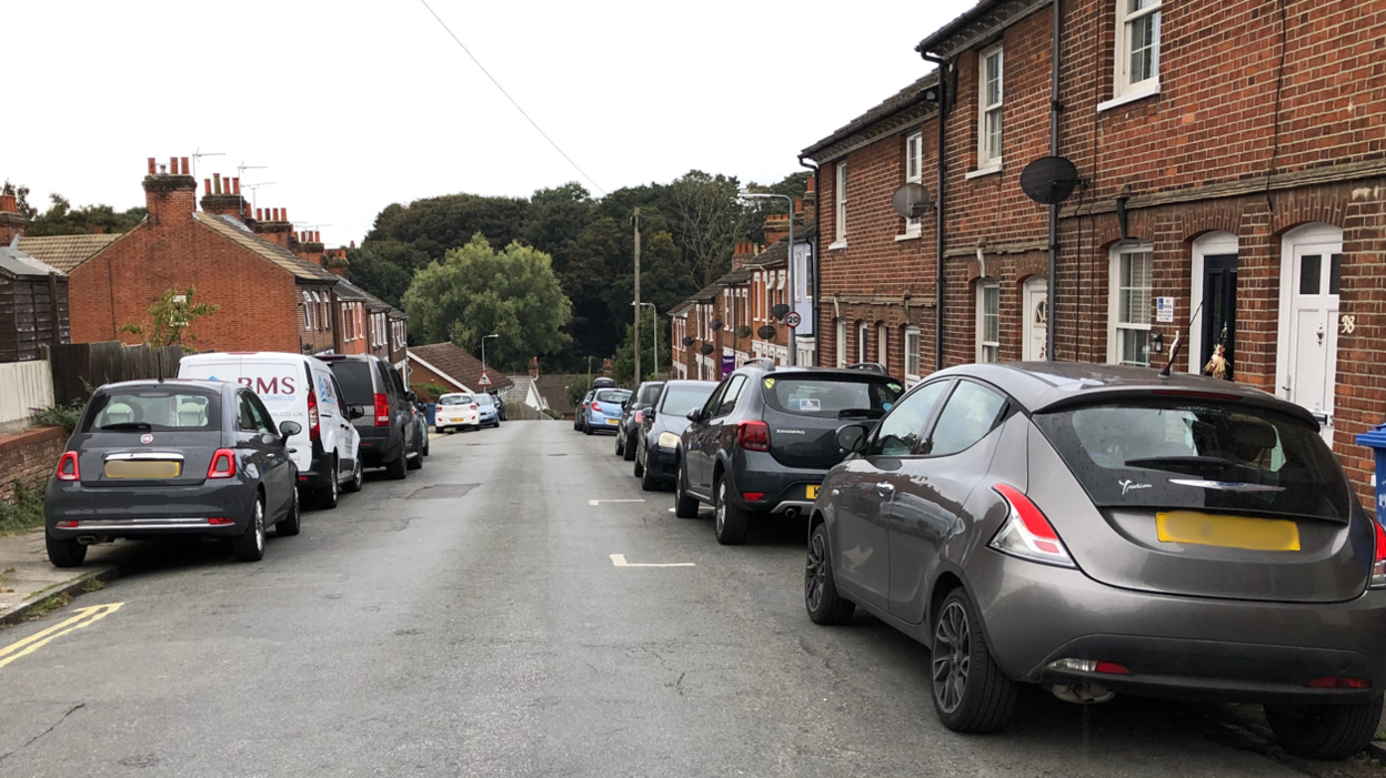 A general view of part of Devonshire Road in Ipswich. It shows a number of cars parked either side of the road. Houses line the street.