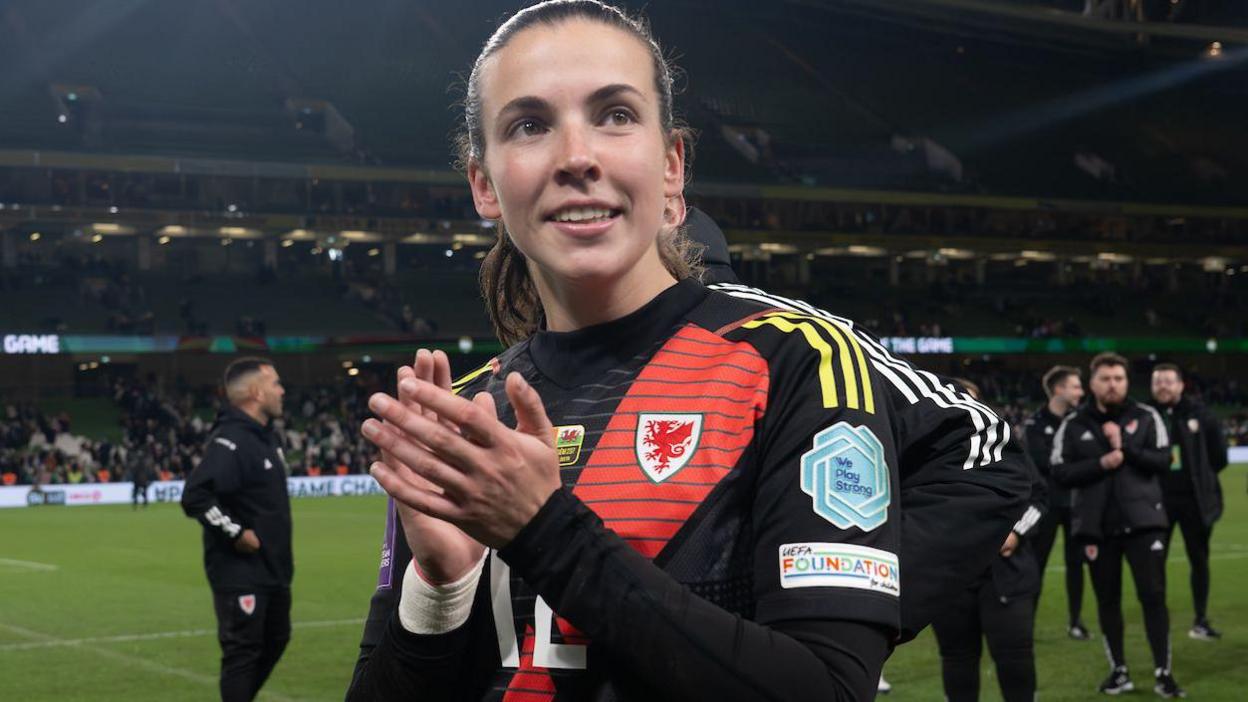 Olivia Clark applauds fans after Wales' win in Dublin