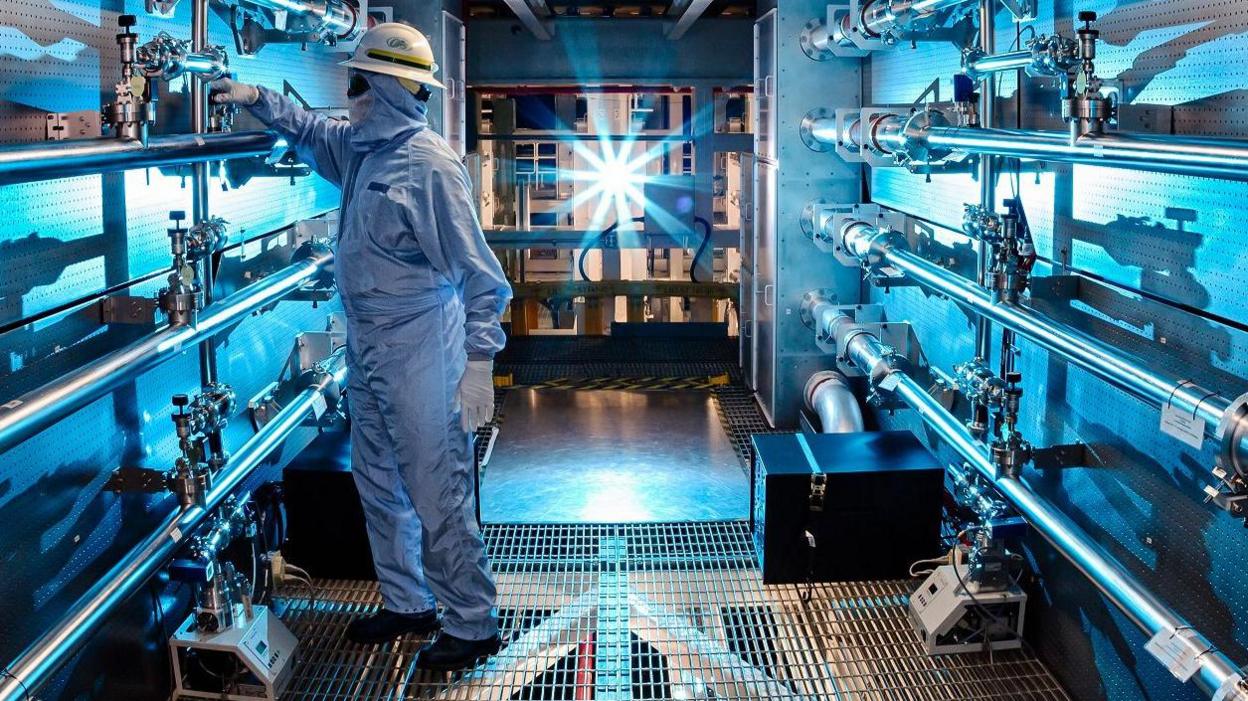 A technician adjusts some of the optical equipment of the National Ignition Facility.