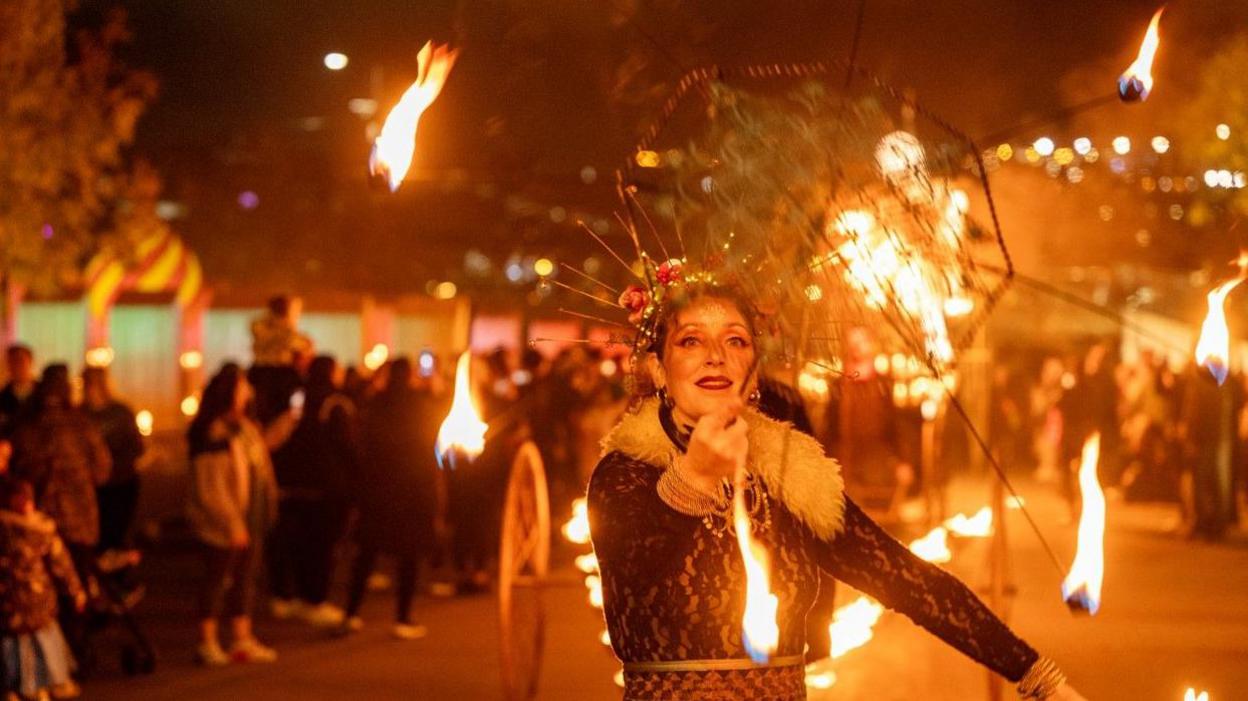 A woman holding an umbrella with fire