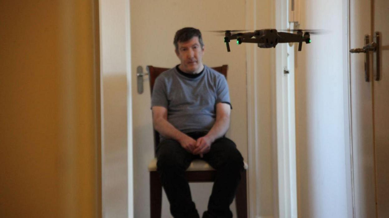 A drone filming a scene of Gary for his art installation