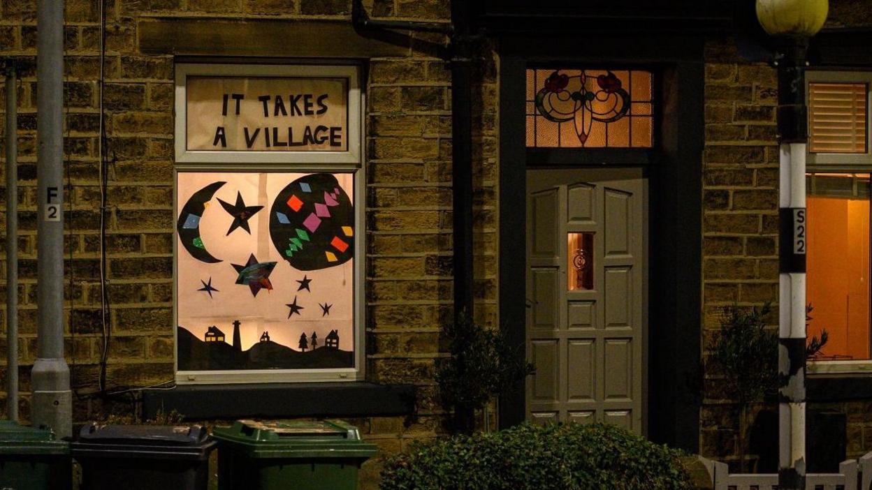 Windows of a terraced house are decorated with homemade artworks as residents take part in the Moonshine Festival of Light