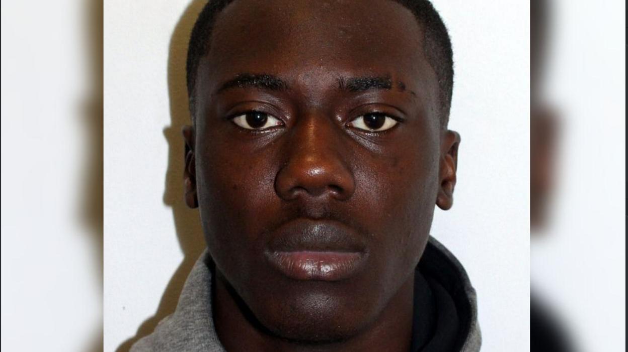 Tyrese Osei-Kofi police mugshot. He is wearing a grey top and is looking at the camera