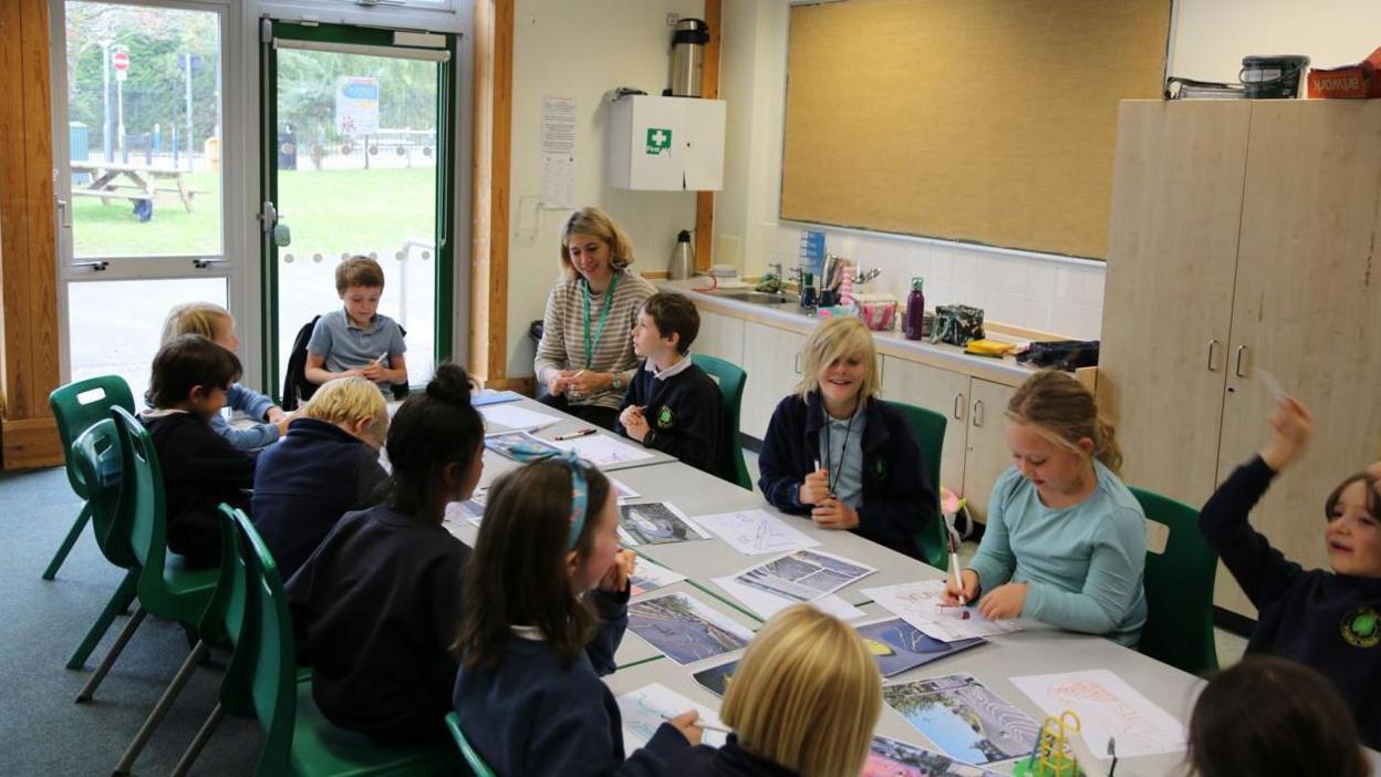 A group of young school children working on designs for a skate park 