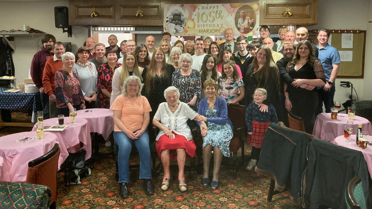 The whole family are pictured together sitting and standing in a large group photograph