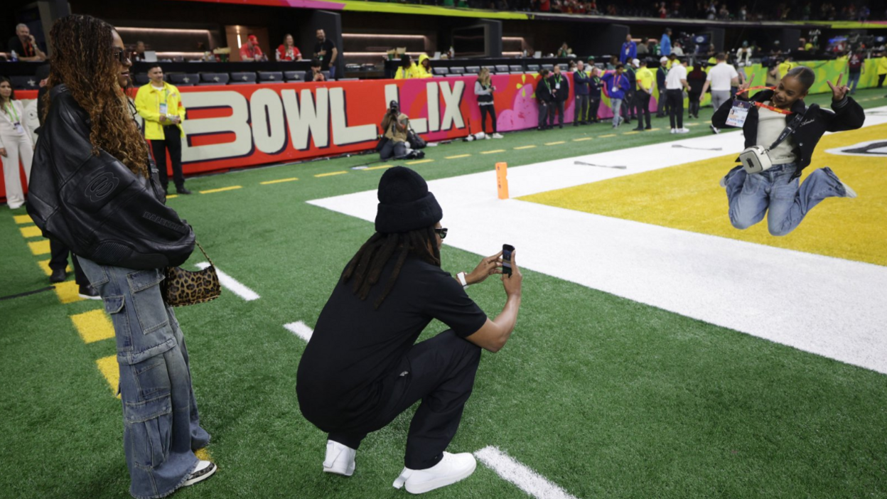 Jay-Z took a few photos of Rumi jump next to one of the endzones as Blue Ivy watches on