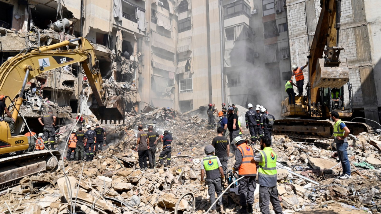 Emergency workers use excavators to clear the rubble at the site which was targeted by an Israeli strike the previous day, in the southern suburb of Beirut, Lebanon