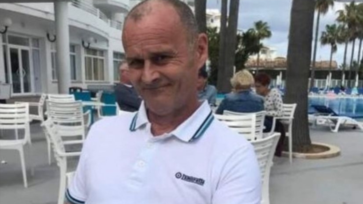 Tony Sayers, in a white polo shirt with palm trees behind him